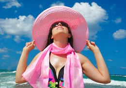 My pink hat / The young woman lifted her head to the sun and keeps the pink hat with both hands
