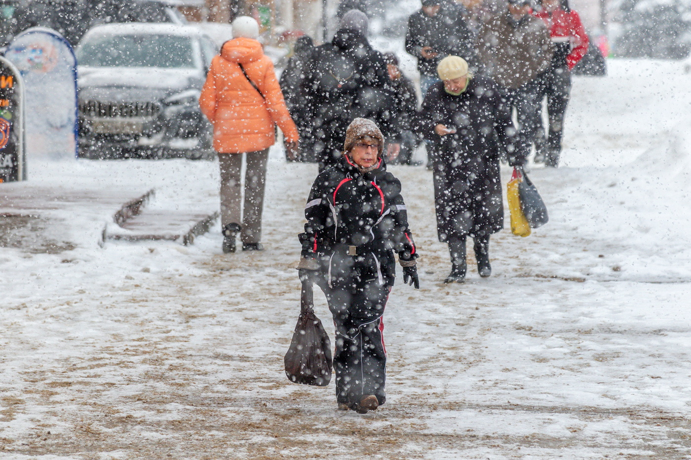 Люди идут и снег идёт.