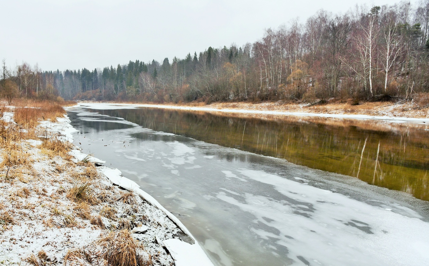Под низким небом, тяжелей свинца, усталая вода сияет тускло..."