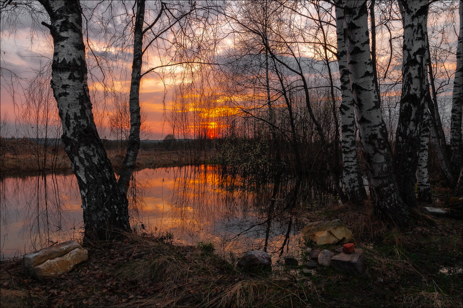 उबदार वसंत ऋतूच्या संध्याकाळी लाल धूळमय सूर्यास्त