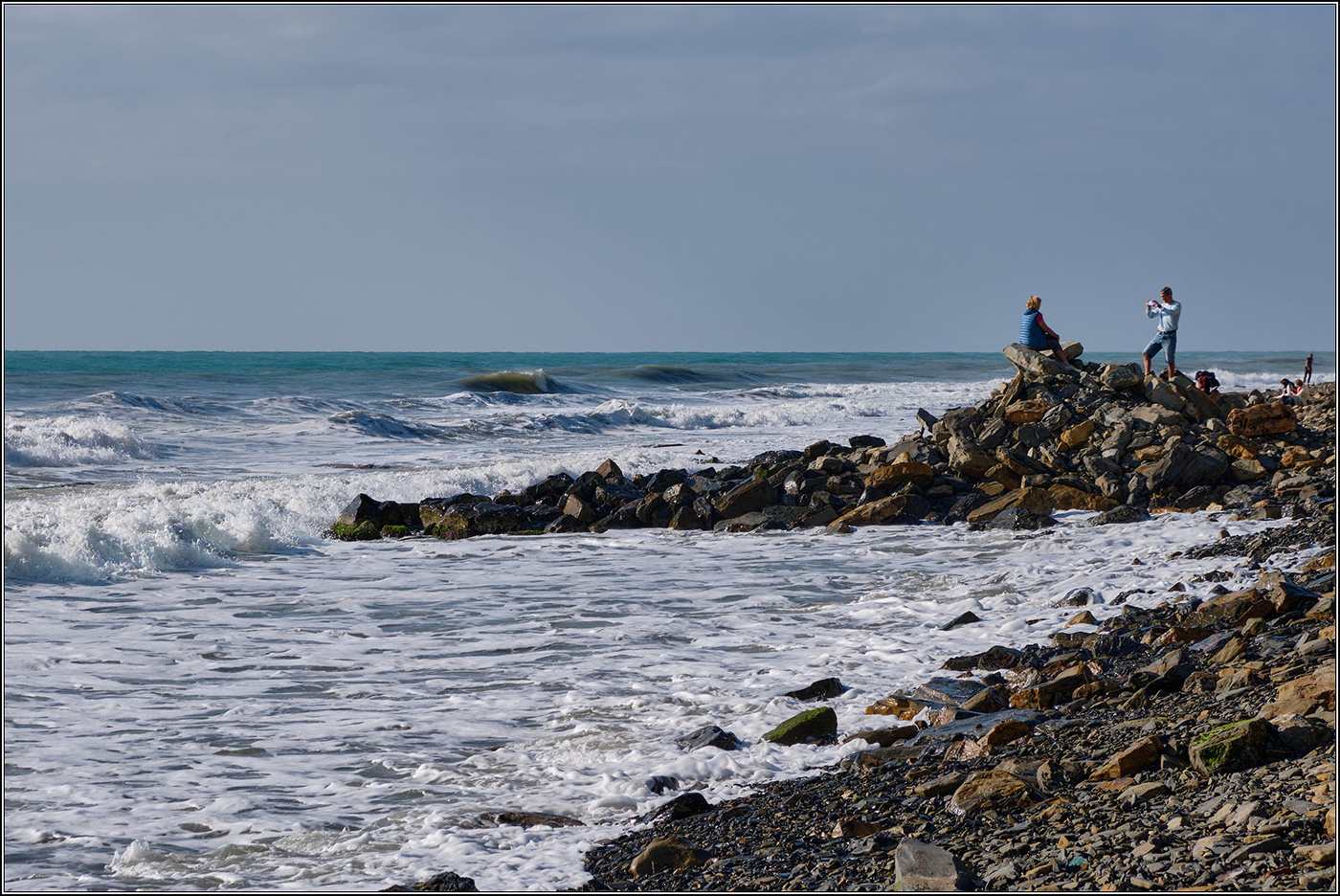 На фоне волн.