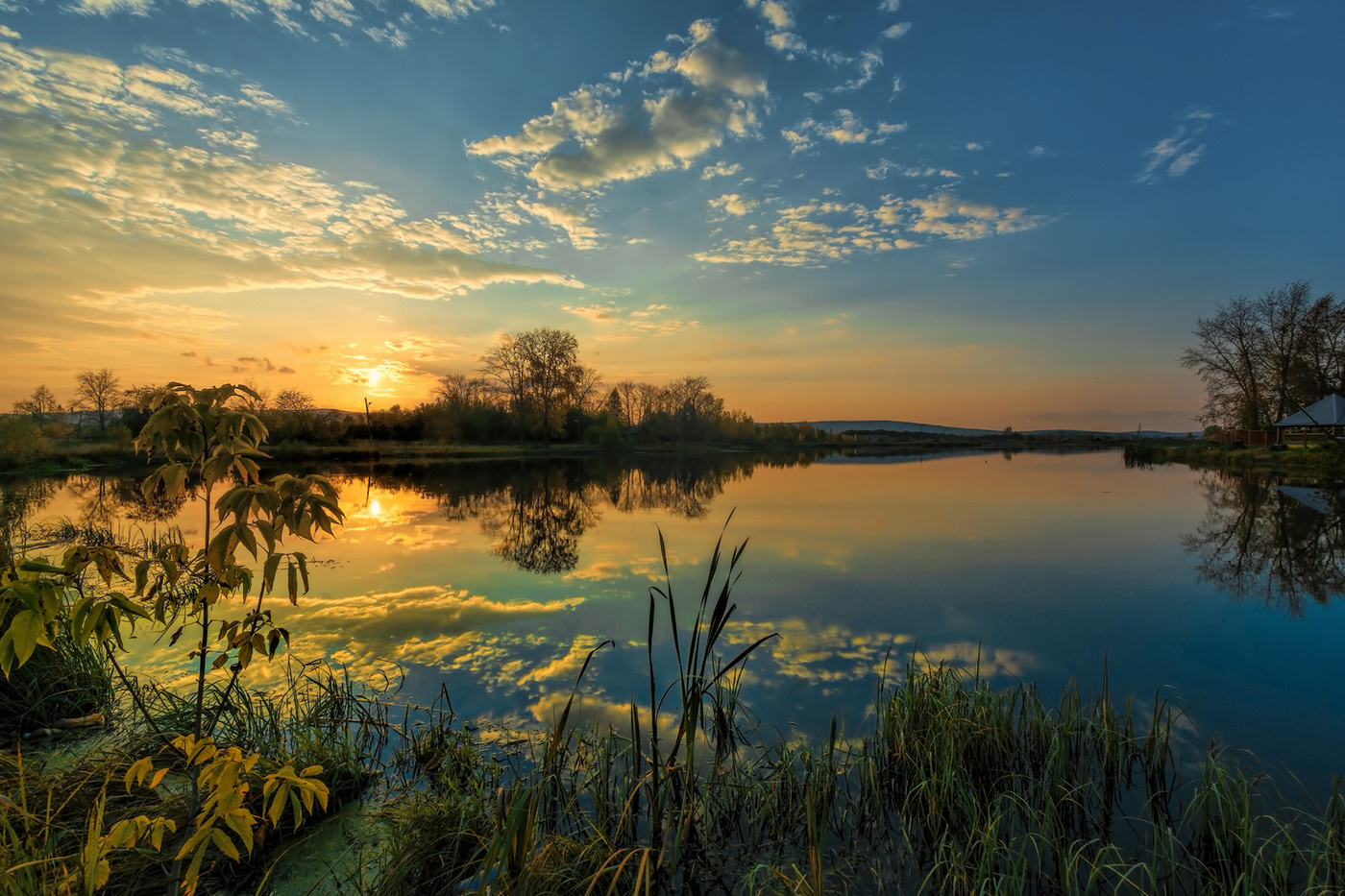 Закат прощальными лучами спокойных вод озолотил стекло