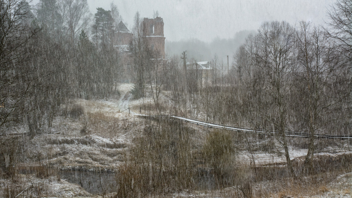 Пейзаж с мостом и старыми постройками в непогоду